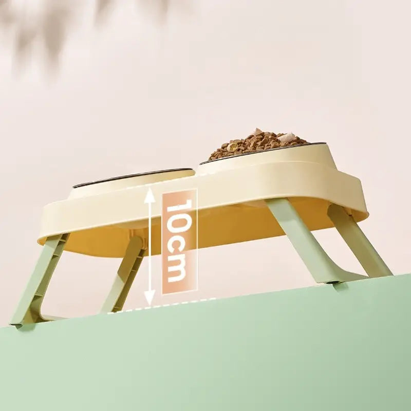 Cream-colored plastic elevated pet feeder with two stainless steel tilt bowls and 10cm height designed for comfortable feeding.