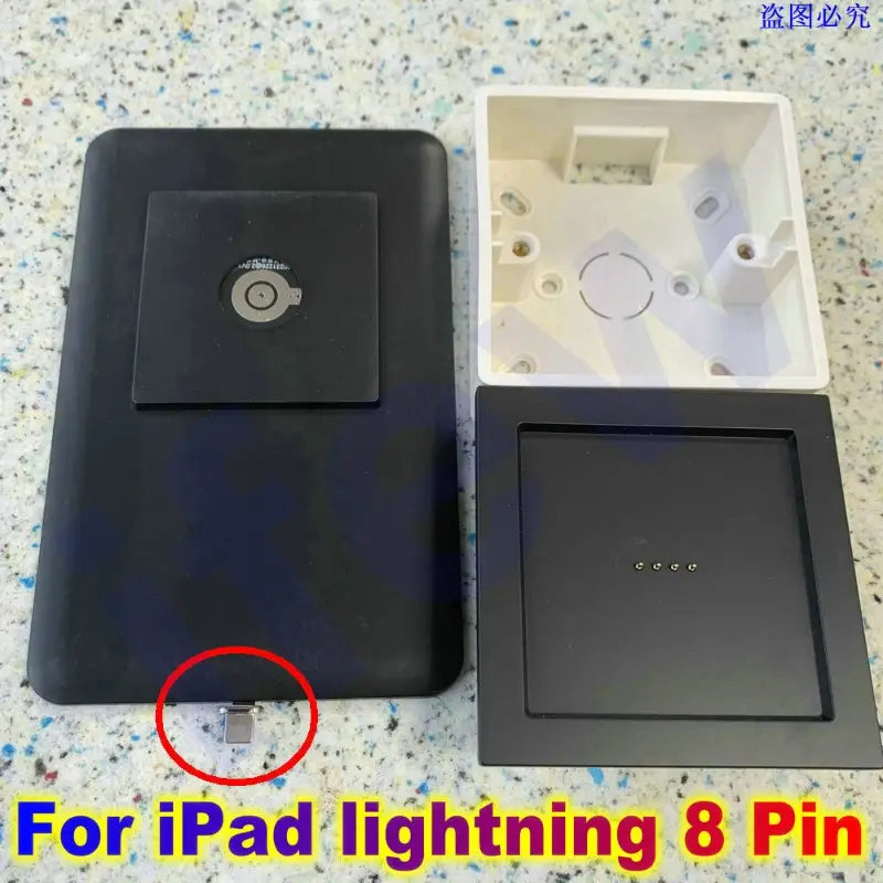 Black rectangular ipad charging dock with a circular power button and 8-pin lightning port designed as a tablet wall mount magnetic bracket for secure ipad charger attachment.