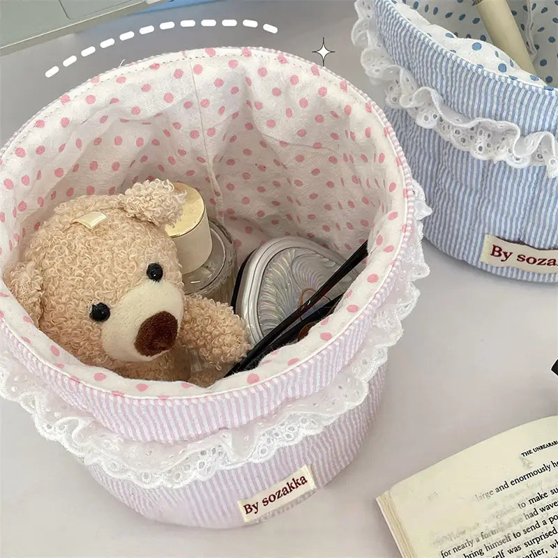 Gepolsterter Aufbewahrungskorb für das Kinderzimmer aus rosa-weiß gestreiftem Stoff mit Spitzenbesatz für eine geordnete Aufbewahrung.