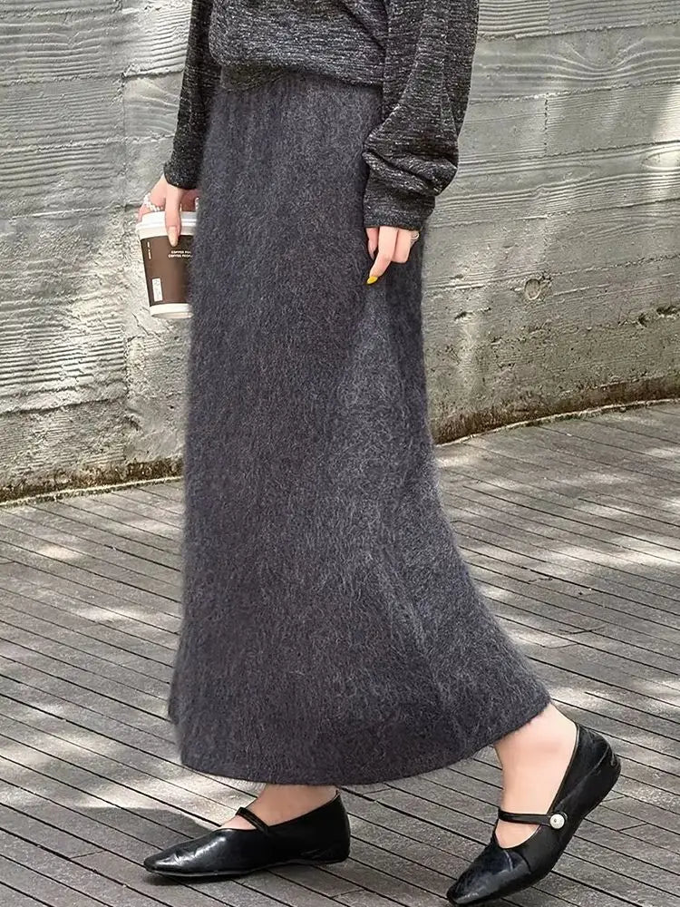 Ein langer dunkelgrauer flauschiger Woll-Midirock aus weichem, texturiertem Strickgewebe.
