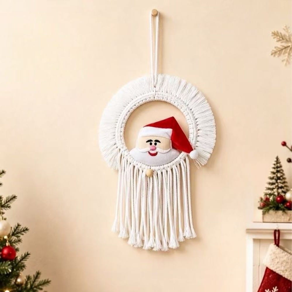 white macrame christmas wall hanging tapestry featuring a plush santa face with a red hat and white beard.