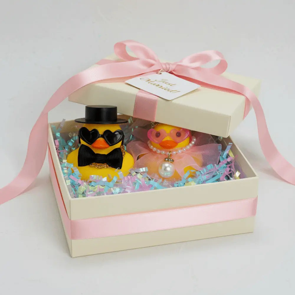 encantador conjunto de adorno de pareja de patito de goma amarillo para boda: un patito vestido con sombrero de copa negro, pajarita y gafas con forma de corazón, y el otro adornado con gafas rosadas, perlas y una diadema.