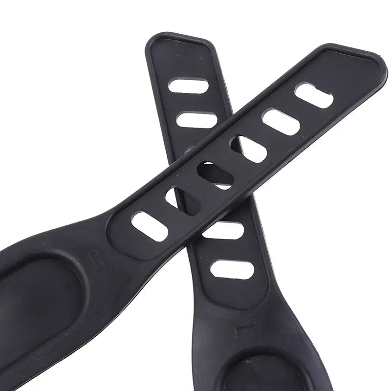 Sangle de pédale de vélo d’exercice en plastique noir avec des découpes ovales allongées et une extrémité arrondie, conçue pour un maintien sûr du pied.
