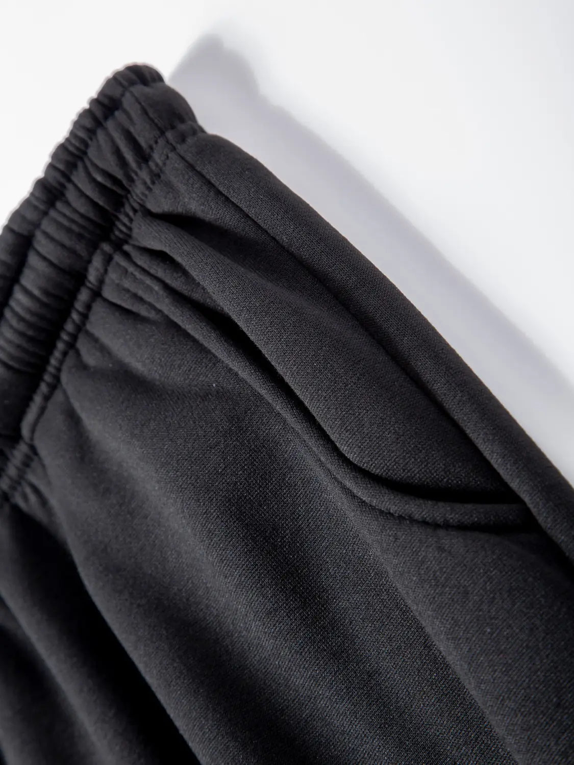 Pantalons de jogging en polaire pour hommes, style décontracté pour l’hiver, noirs, avec taille élastique, fabriqués dans un tissu en polaire texturée douce, présentant des détails de couture discrets.