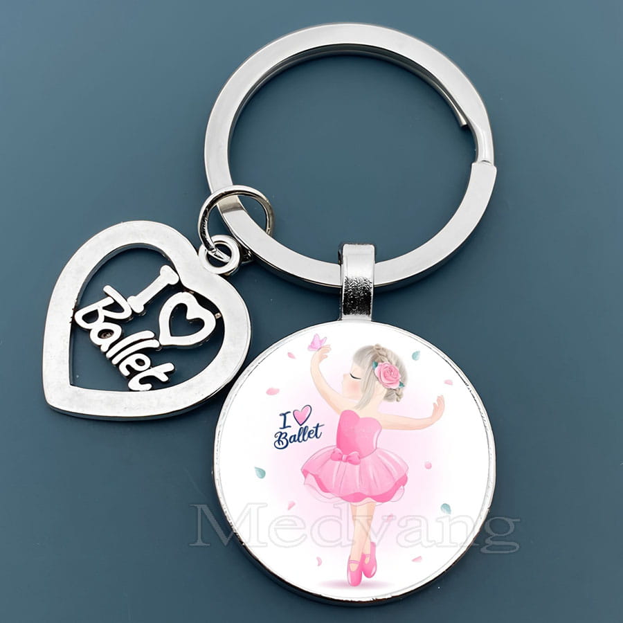 「I love ballet」と刻印された銀色のハート形チャームと、ピンクのバレエダンサーのイラストが入った丸いガラスドームのキーチェーンペンダント。バレエギフト向けのデザイン。