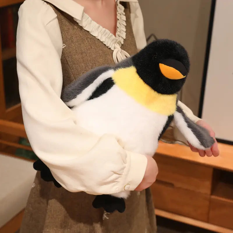 a plush penguin stuffed animal soft toy pair featuring a plush penguin-shaped bag with a black head, yellow chest patch, white belly, and gray wings