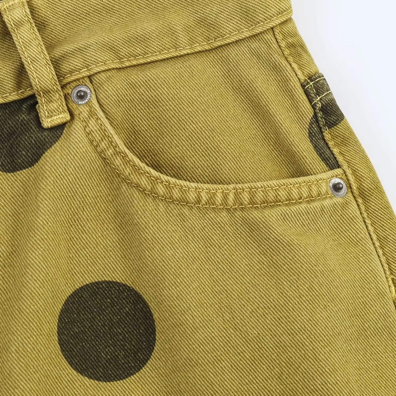 Olivgrüne Denim-Jeans mit weitem Bein, mit kräftigen schwarzen Polka-Dots und silberfarbenen Nieten, gestaltet als Hosen mit hoher Taille.