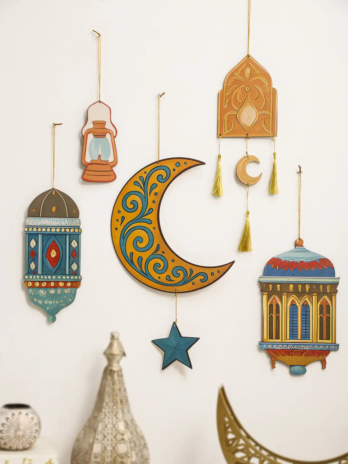 Un ornamento de farol de luna y estrella para decoración de pared de Ramadán islámico, de madera pintada a mano y de estilo vibrante, con remolinos teal intrincados y una estrella azul colgante en estilo moderno.