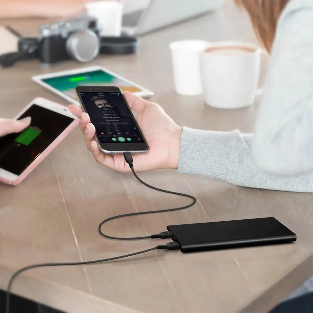 Banco de energía portátil negro rectangular de 20000 mAh con dos puertos USB y un diseño minimalista elegante para prendas térmicas.