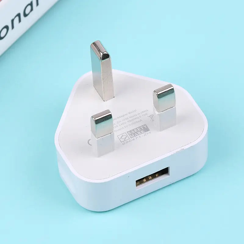 Adaptador de cargador de pared doble USB de 3 clavijas tipo Reino Unido en plástico blanco que muestra la parte posterior con tres clavijas metálicas y un puerto USB.