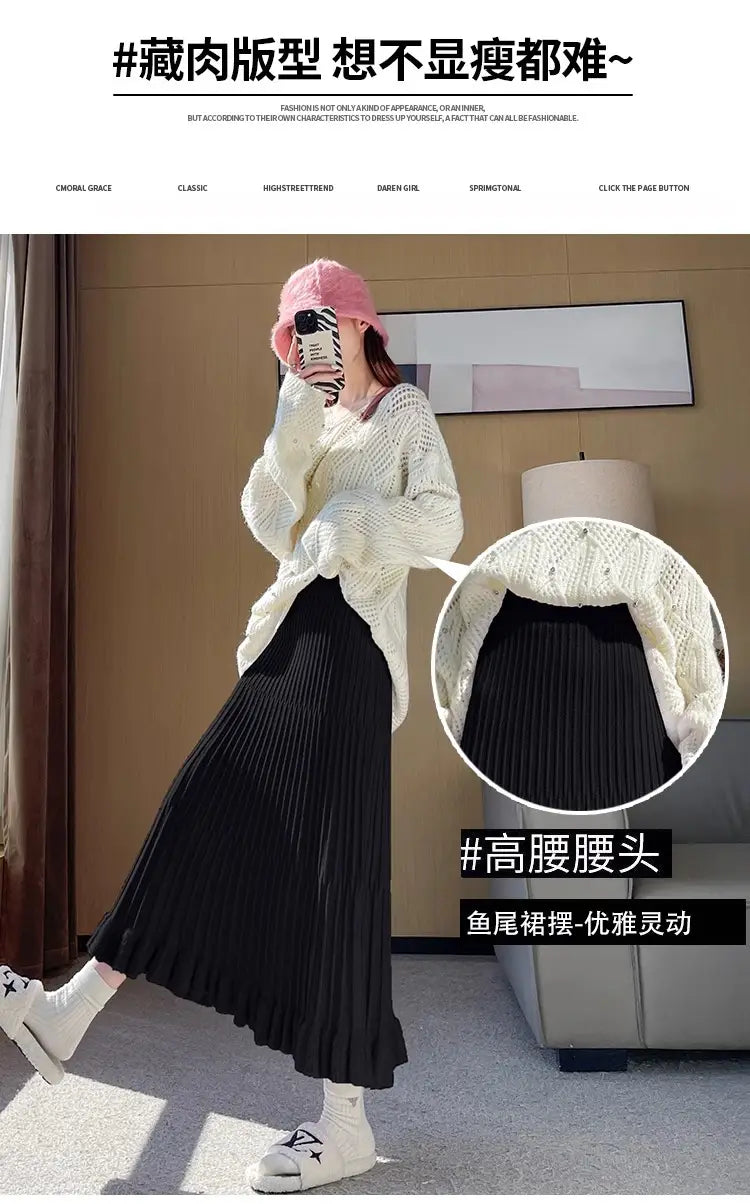 Jupe mi-longue en maille noire, avec design parapluie à plis à taille haute et ourlet queue-de-poisson.