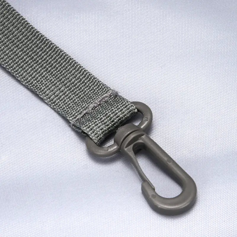 Correa de cincha gris con mosquetón metálico gris a juego en una mochila de viaje para mascotas de tela Oxford para caminatas, con suministros para mascotas.