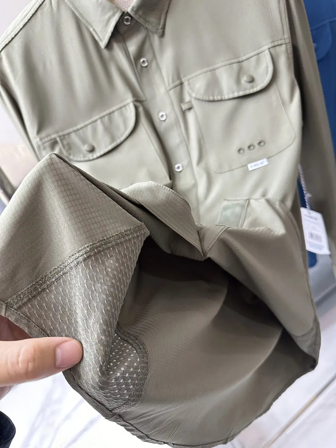 Men’s tactical outdoor long sleeve khaki shirt with two chest pockets and subtle textured lining on the inner sleeve.