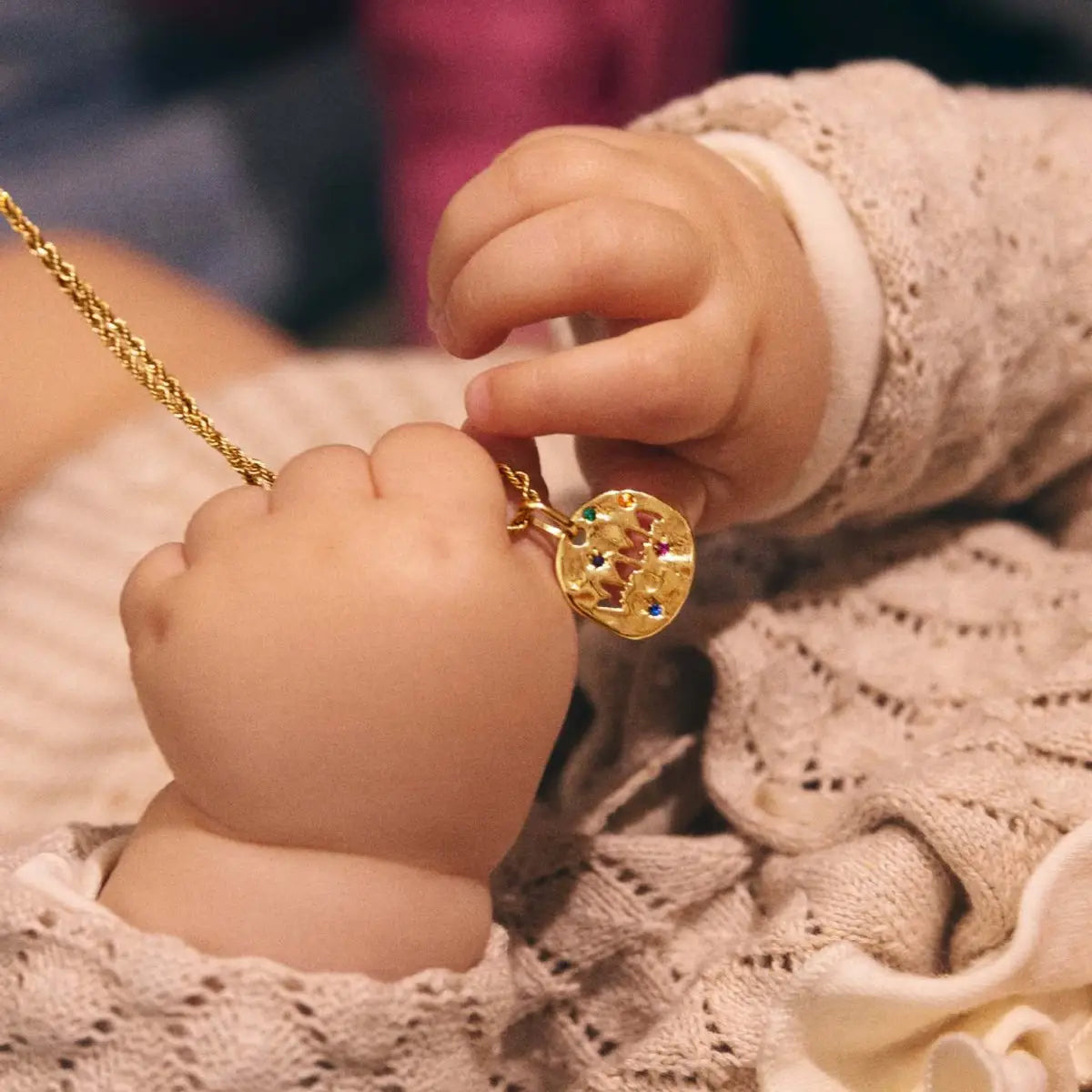 Collier en acier inoxydable doré avec pendentif en pierre précieuse « Mama », doté d'un pendentif rond ornementé comprenant des pierres précieuses colorées intégrées.