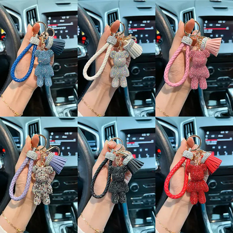 A sparkling rhinestone-encrusted bear keychain with a braided leather strap and matching tassel in assorted vibrant colors.