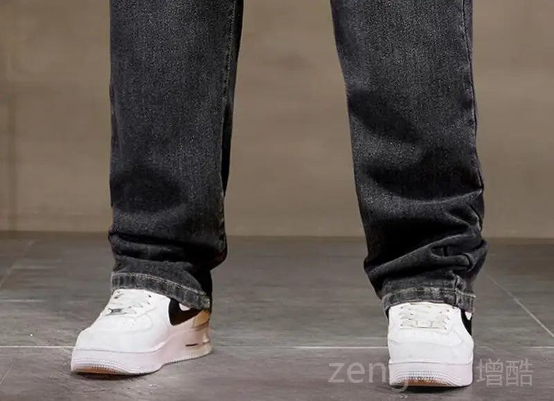 white Nike Air Force 1 sneakers with black swooshes and a gum-colored sole paired with plus size elastic waist loose straight jeans.
