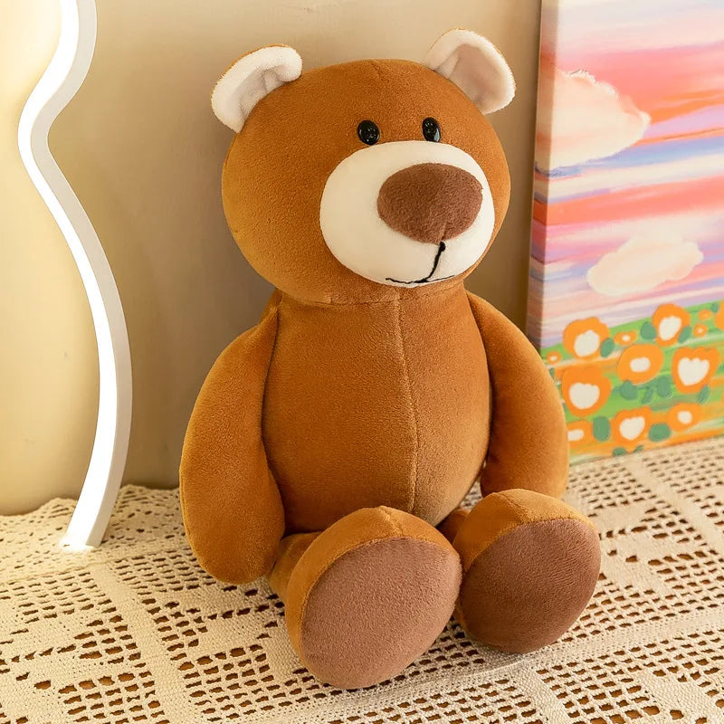 Un peluche de oso de peluche marrón con orejas internas blancas, hocico y nariz color crema, y sencillos ojos negros tipo botón, de la colección de muñecos blandos de animales de la jungla.