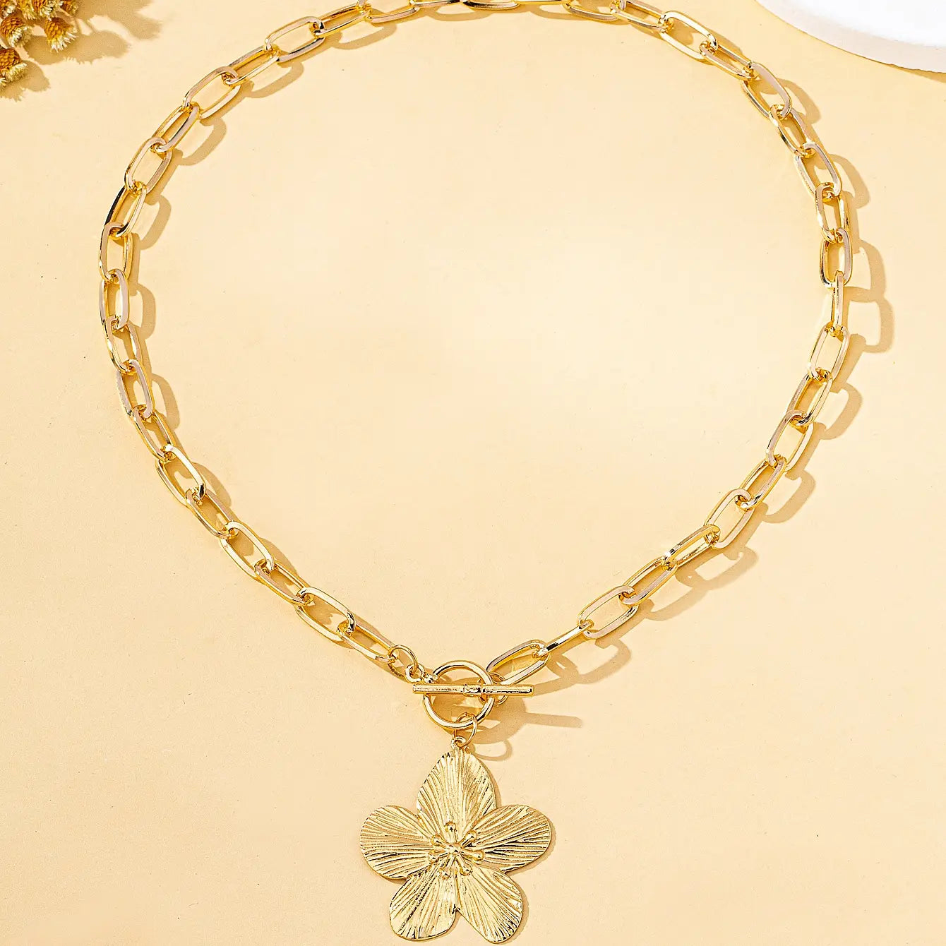 Collier pendentif plaqué or avec un pendentif de fleur de glycine à cinq pétales texturé et une attache à bascule, conçu pour femmes, style vintage.