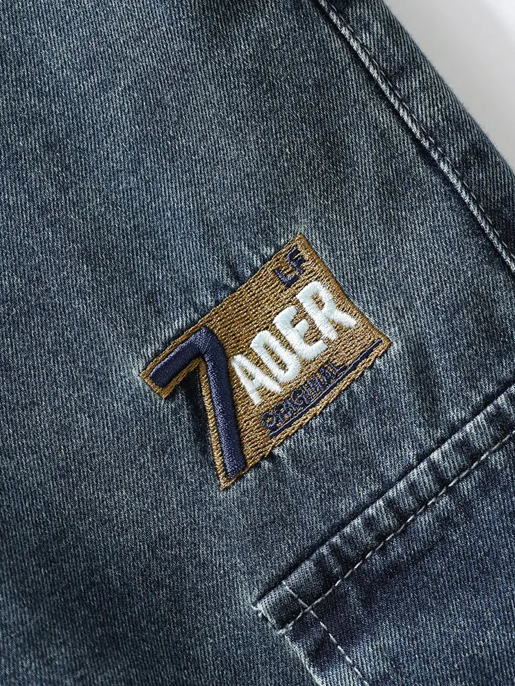 Jean cargo en denim ample pour homme, grande taille, fabriqué dans un denim bleu foncé : patch brodé marron au dos avec le mot Zader en fil blanc et bleu marine.