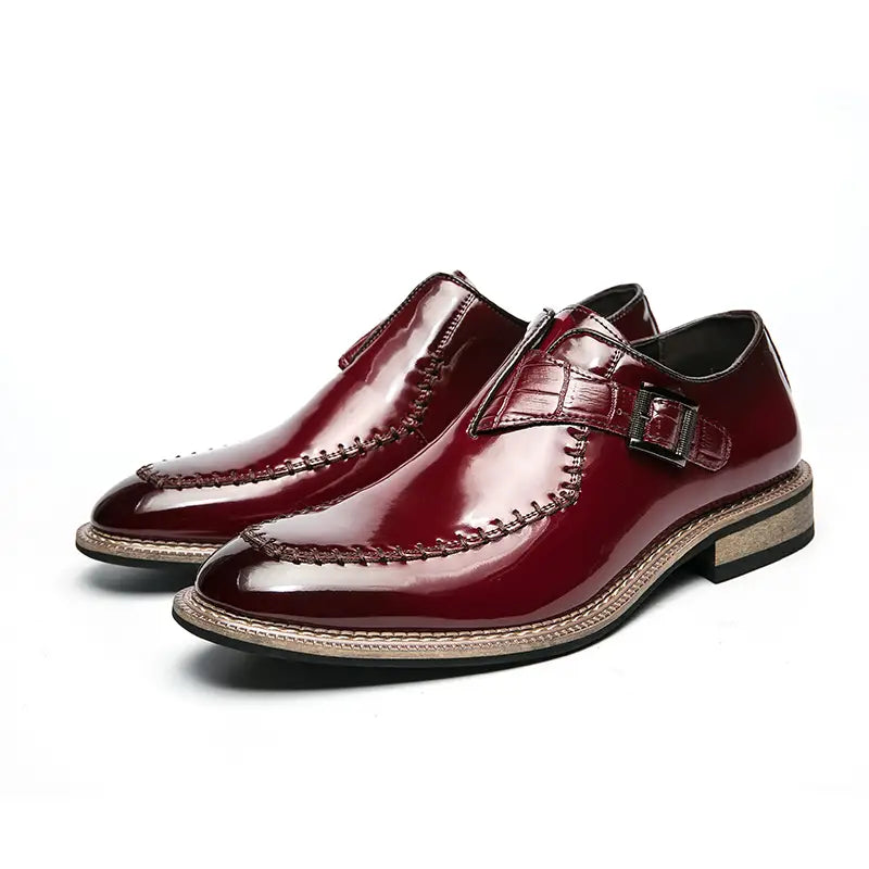 Herren glänzende Lackleder-Kleiderschuhe in poliertem Burgunder mit krokodilartig strukturierter Riemenführung und metallicfarbenem Schnallen-Slip-on-Design.
