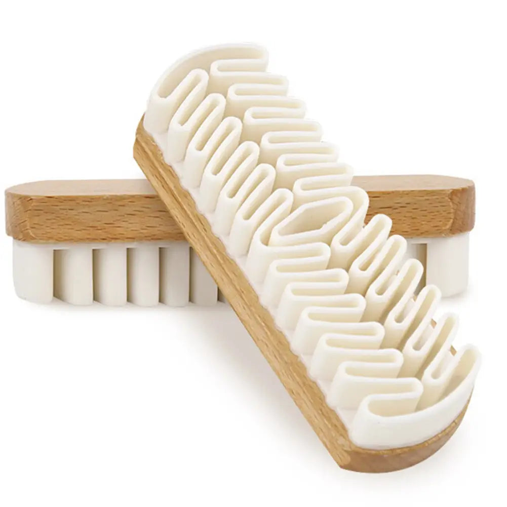 Cepillo de limpieza para interior de coche de ante Alcántara con cerdas blancas tipo cepillo para zapatos, mango de madera clara y un patrón zigzag único de cerdas rígidas diseñado para limpiar y pulir zapatos.