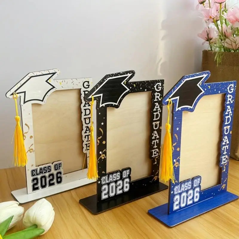 class of 2026 wooden graduation photo frame set featuring three decorative frames in white, black, and blue with mortarboard tops and yellow tassels.