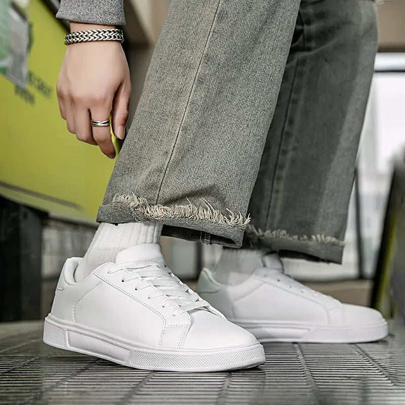 Weiße Ledersneaker im Freizeitstil mit einem klaren minimalistischen Design und dezenten Ziernähte-Details, leichte Sportschuhe.