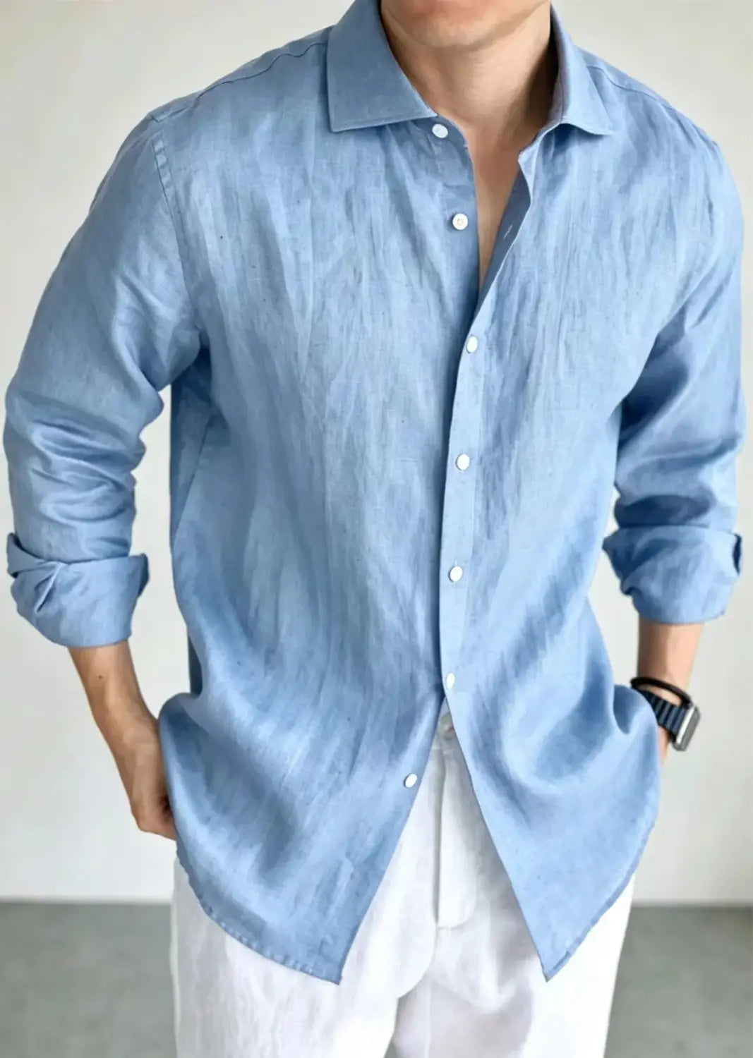 A light blue men cotton linen casual button down shirt with long sleeves, classic collar, and rolled cuffs.