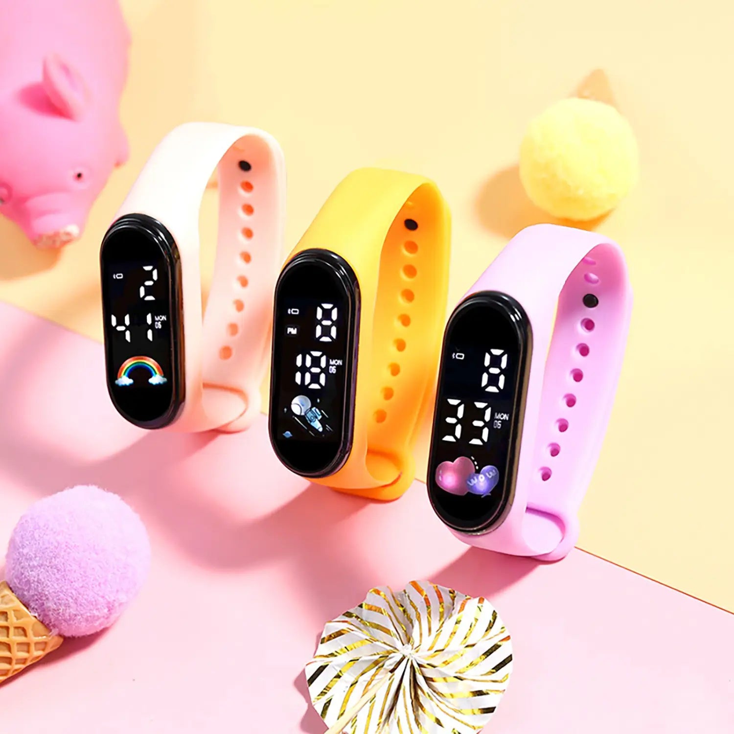 Three colorful kids digital LED silicone sports watches with digital displays in pastel white, yellow, and pink featuring animated icons and time on their screens.