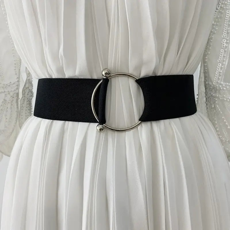 Damen-Elastikgürtel mit schwarzem elastischem Band, einem eleganten runden silberfarbenen Schnallenverschluss und kleinen kugelförmigen Akzenten zur Verwendung als Taillenbund bei Modekleidern.