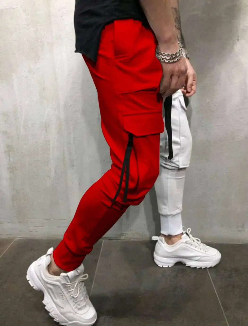Pantalones cargo tipo jogger rojos con rayas laterales negras y cordones, diseñados como pantalones cargo tipo jogger de hip hop con bloques de color y ropa urbana.