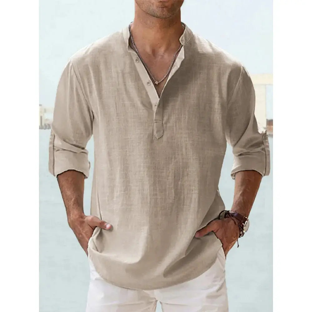 Chemise en lin henley beige pour homme, manches longues retroussées et texture discrète, idéale pour une tenue décontractée d’été à la plage.