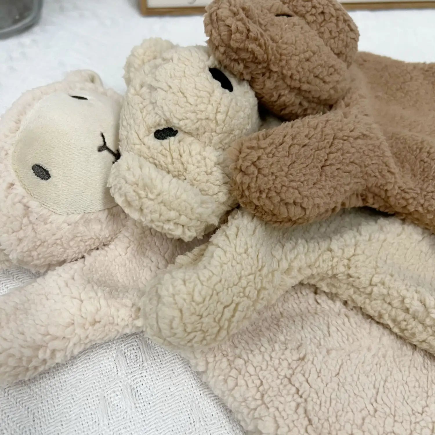 クリームとタンのフリースで作られた、刺繍による黒い目を備えた、柔らかなぬいぐるみテディベア型スリッパ。ベビー向けなだめ用ぬいぐるみベアの人形写真撮影用小道具として使用します。