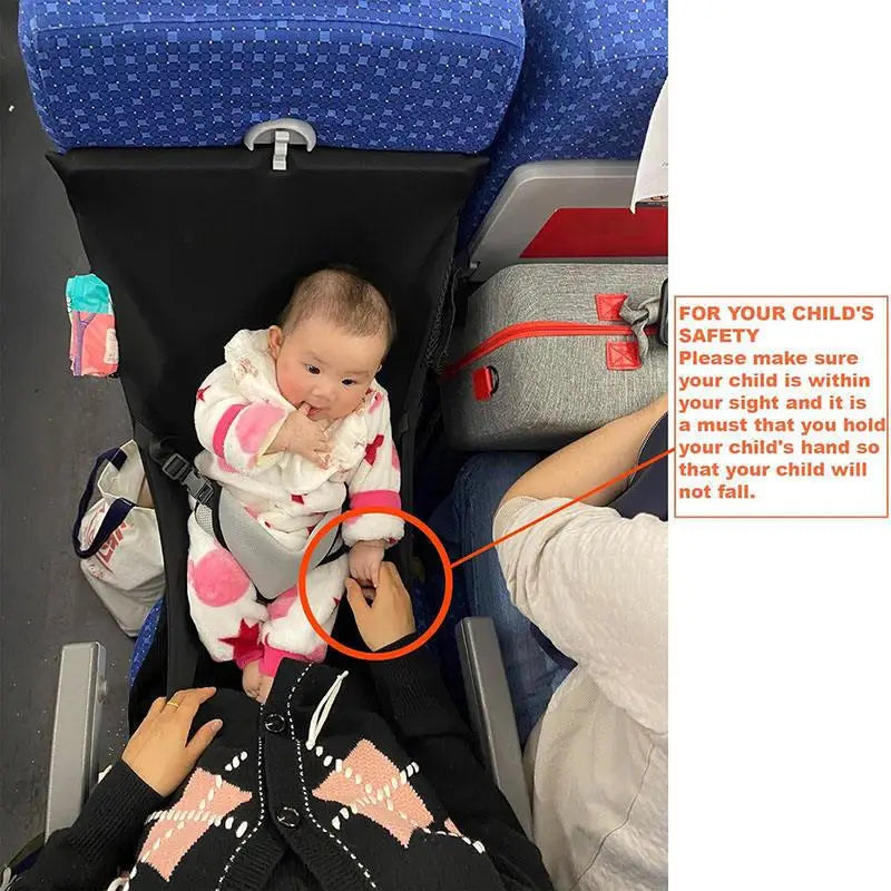 Ein Baby in einem weißen und rosa Sternen-Muster-Outfit sitzt auf einem Flugzeugsitz, der von einem Erwachsenen mit einer tragbaren Flugzeugbett-Fußstütze für Kinder und Kleinkinder gehalten wird.