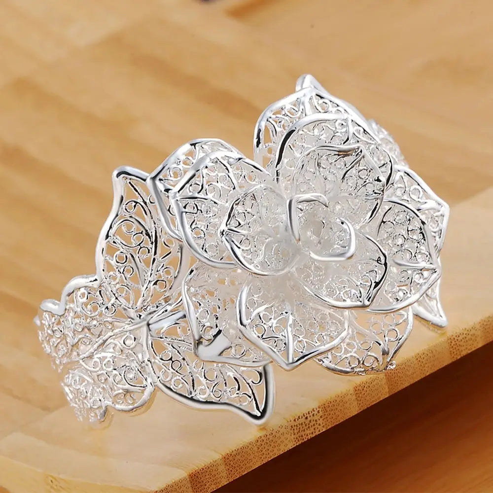 Bracelet manchette floral en argent sterling, avec un filigrane de dentelle complexe, provenant d’un ensemble de bijoux floraux.