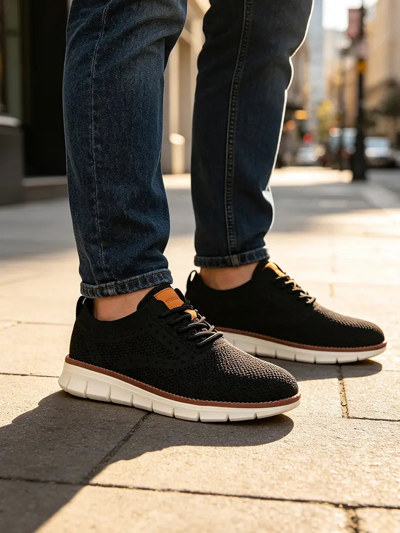 Zapatillas casual de punto para hombre en negro con acentos blanco y camel; cuentan con una parte superior transpirable y un diseño elegante, ideal para caminar.