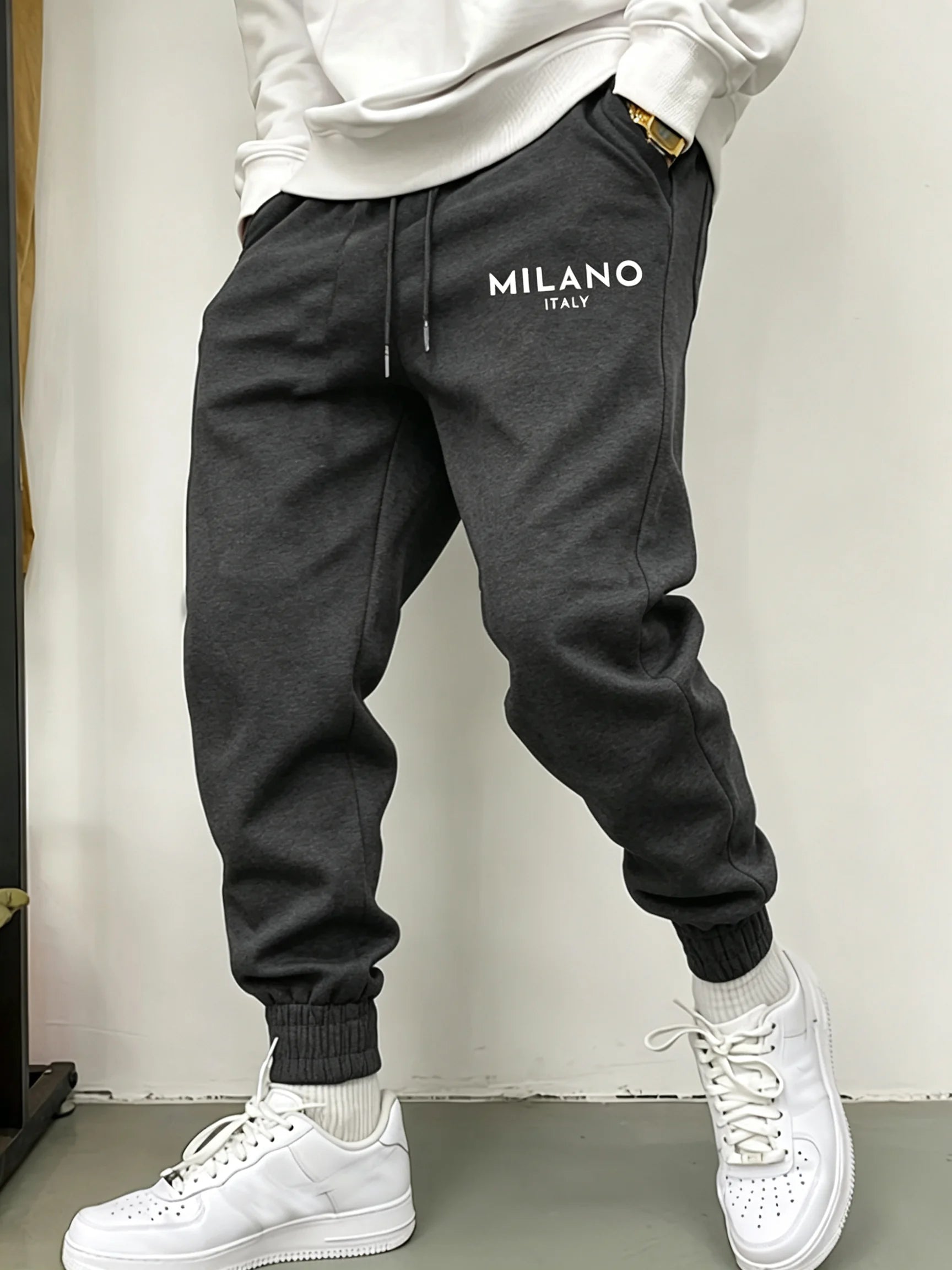 Dunkelgraue Fleece-Jogginghosen für Herren mit in Weiß auf der linken Oberschenkelseite besticktem Milano, Italien.