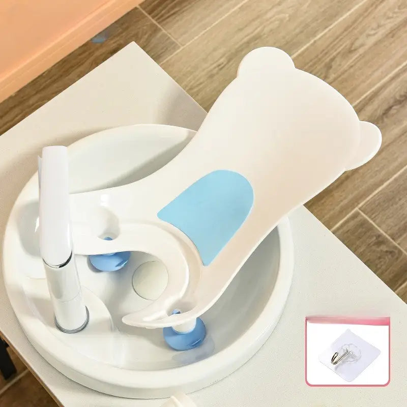 白色と淡い青色の、クマの形をしたベビーバム用おしり洗浄器。吸盤付きで、シンク内に確実に設置できます。