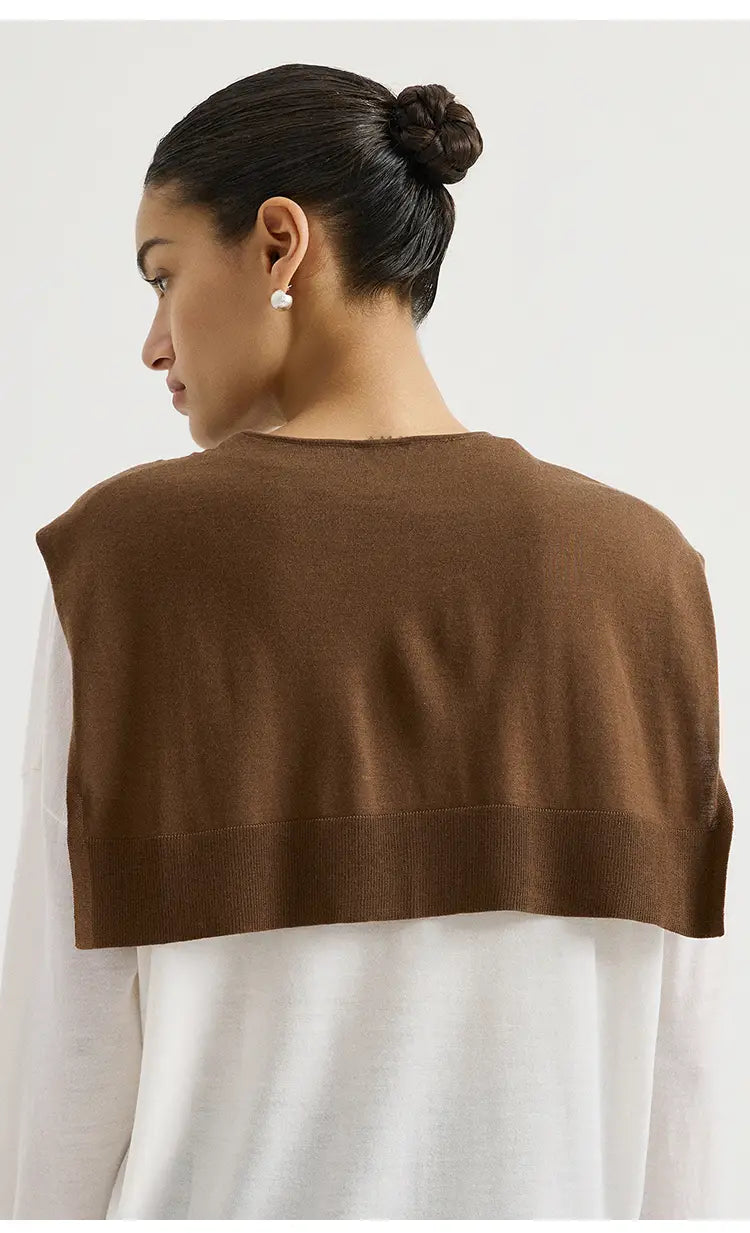 Braunes gestricktes ärmelloses Oberteil, getragen über einem weißen Langarmhemd, im Stil mit dem Wollstrick-Schulterwickel-Cape-Schal.