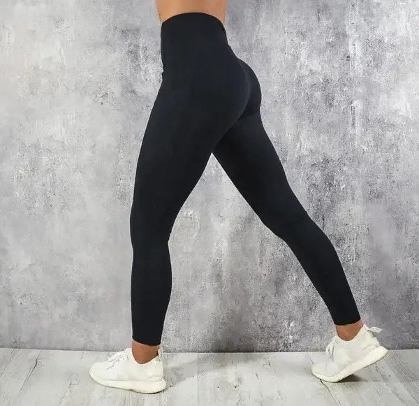 black high-waisted booty lifting pocket leggings made of stretchy, form-fitting material shown from the back side