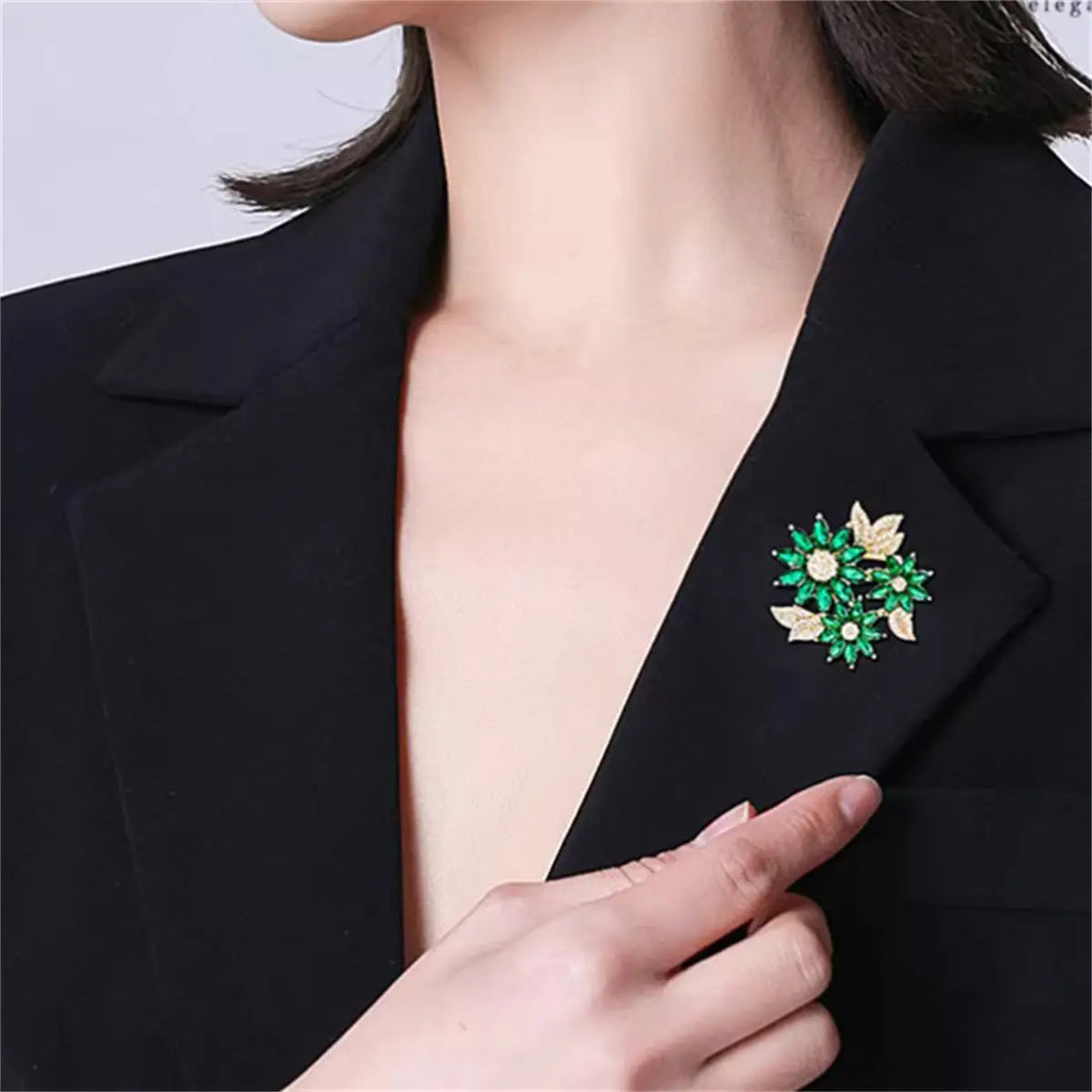 emerald green and gold leaf-shaped rhinestone brooch pin adorned on a black blazer lapel as a green floral accessory