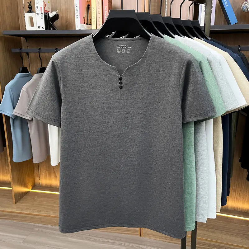 Camisa tipo henley para hombre de manga corta en tejido gris jaspeado, con tres botones negros en el cuello, para una camiseta informal tipo henley con textura.