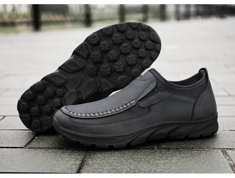 Mocassins homme décontractés à enfiler en cuir noir, avec semelle en caoutchouc texturée et détails cousus.