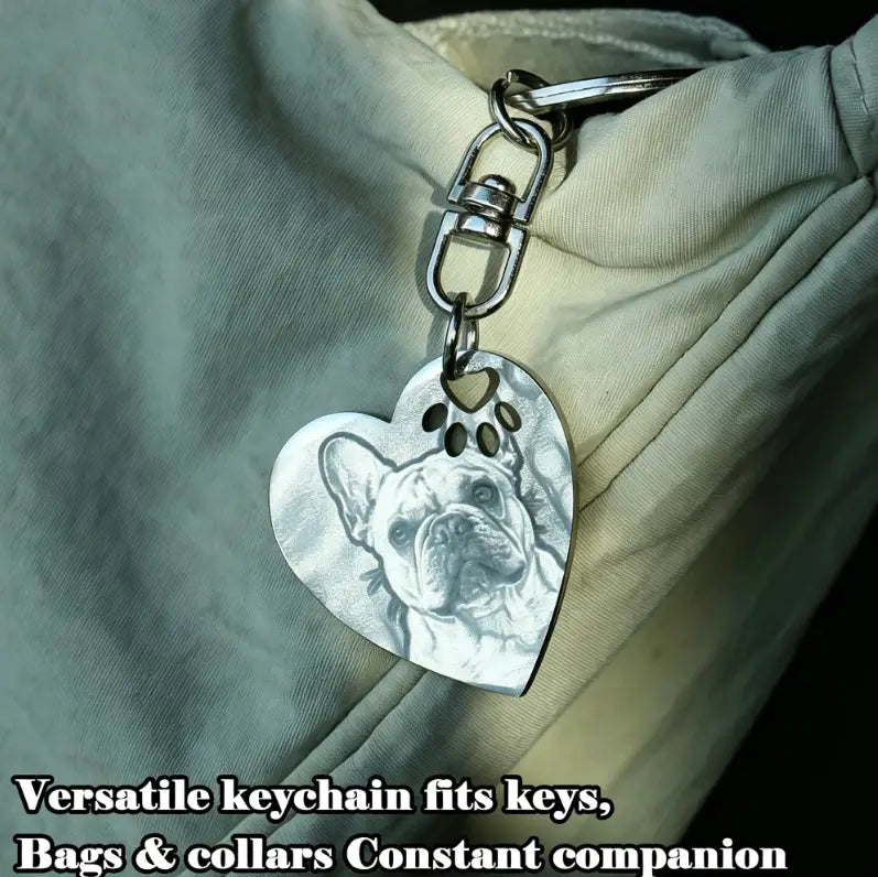 Silver heart-shaped stainless steel keychain featuring an engraved portrait of a French bulldog with a paw print cutout custom pet photo design.