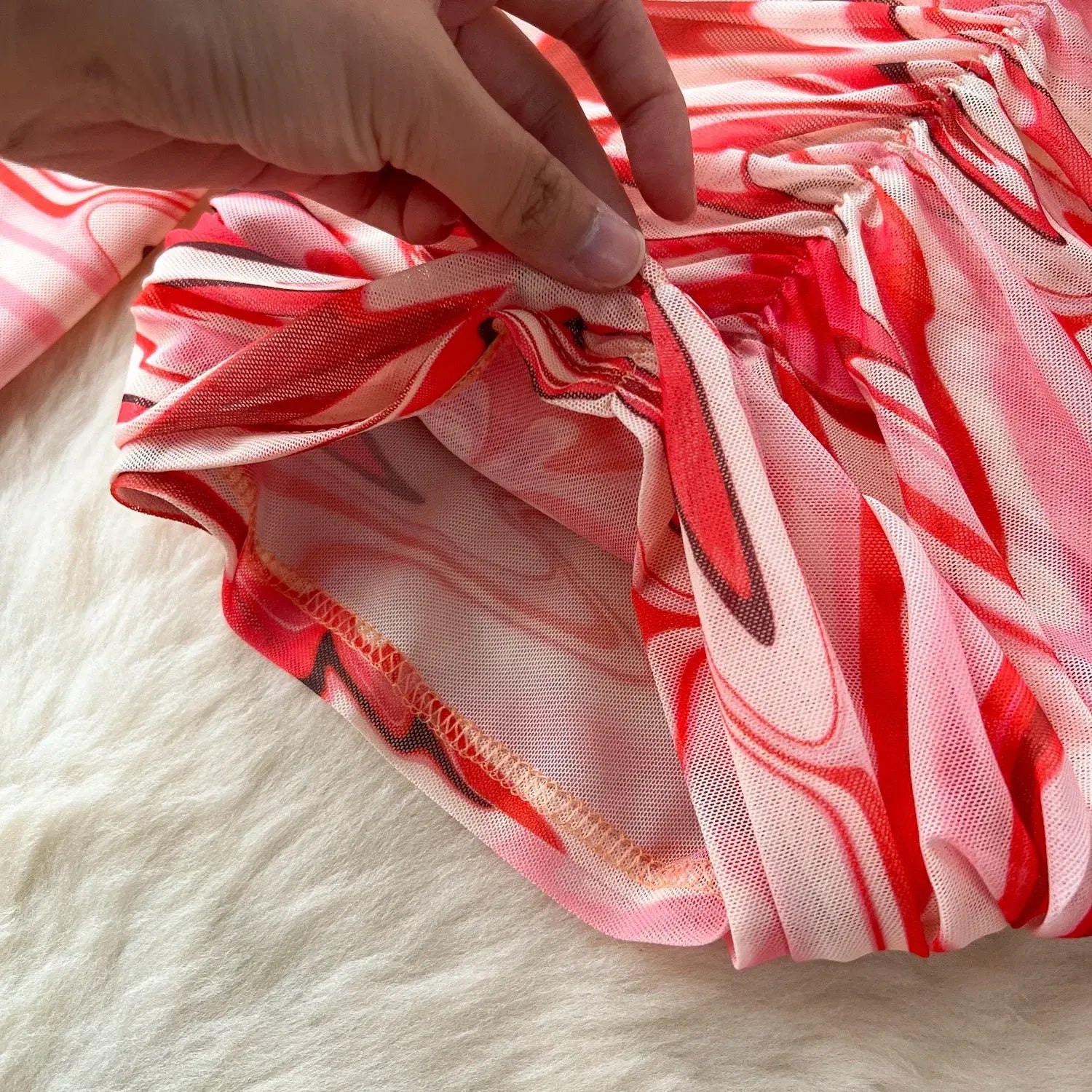 two piece mesh skirt set in vibrant red and pink marble print sheer fabric with delicate ruched texture and elastic closure.