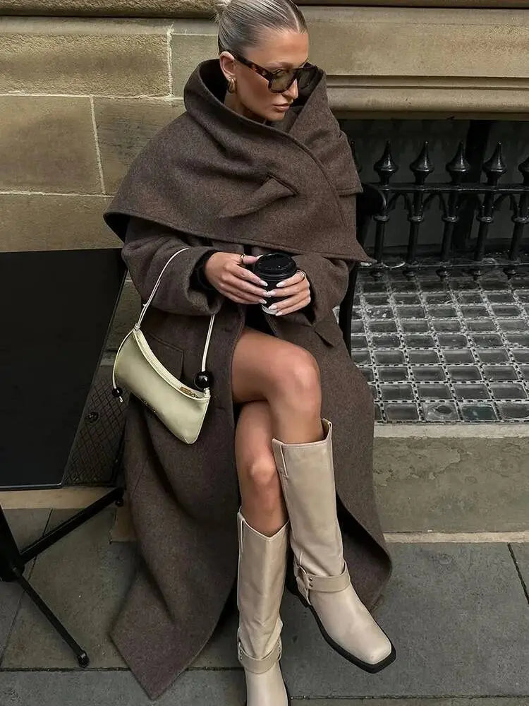 cream-colored leather crossbody bag with sleek minimalist design and small black bead accent shown with brown wool blend overcoat women winter commuter jacket