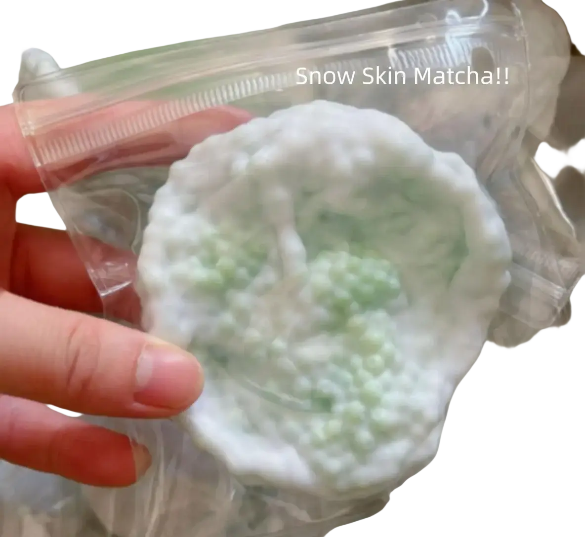 A round white and light green matcha-flavored snow skin squishy toy with a textured surface shown from the front angle