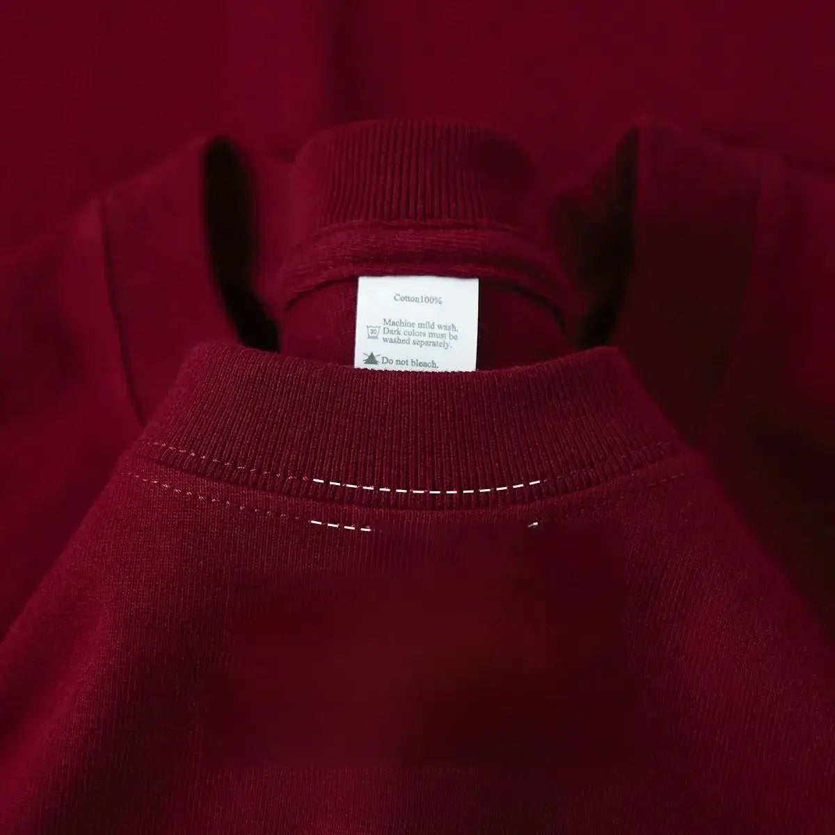 Una sudadera de algodón rojo intenso con cuello redondo acanalado y costuras blancas a lo largo de la zona del cuello.