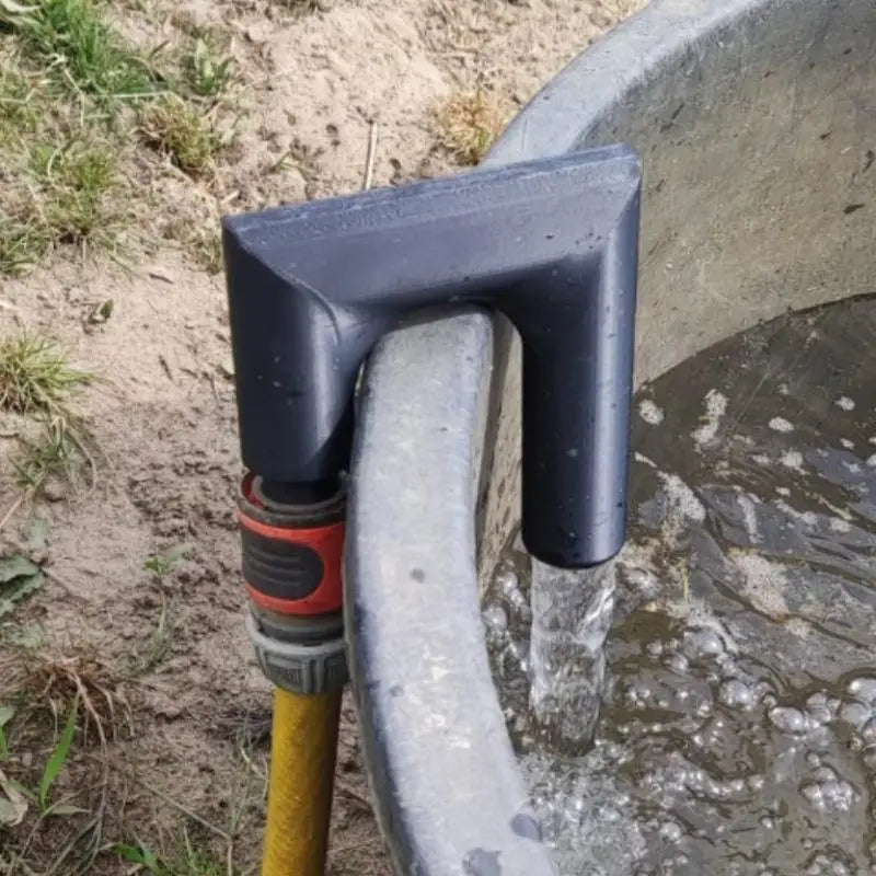black plastic hose clamp securing a yellow garden hose made of printed PLA polylactic acid to a gray concrete trough for efficient water flow