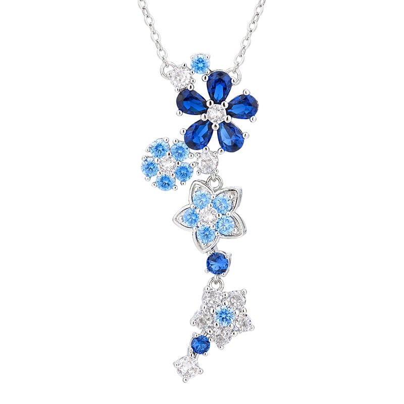 繊細なシルバーの花ジルコンのネックレスおよびブレスレットセット。深いブルーと淡いブルーのジェムストーンを使用し、きらめくクリアストーンで縁取った、滝のように連なるフローラルチャームを特徴とします。